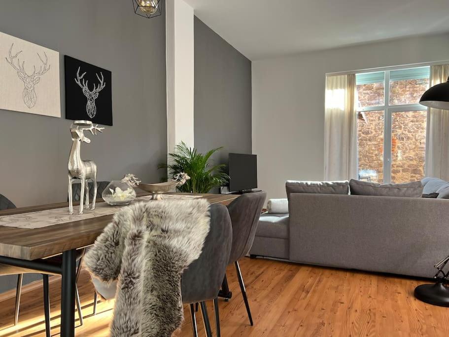 een woonkamer met een tafel en een bank bij AKK5 Großes Apartment mit Terrasse Nähe Hbf/Uni in Maagdenburg