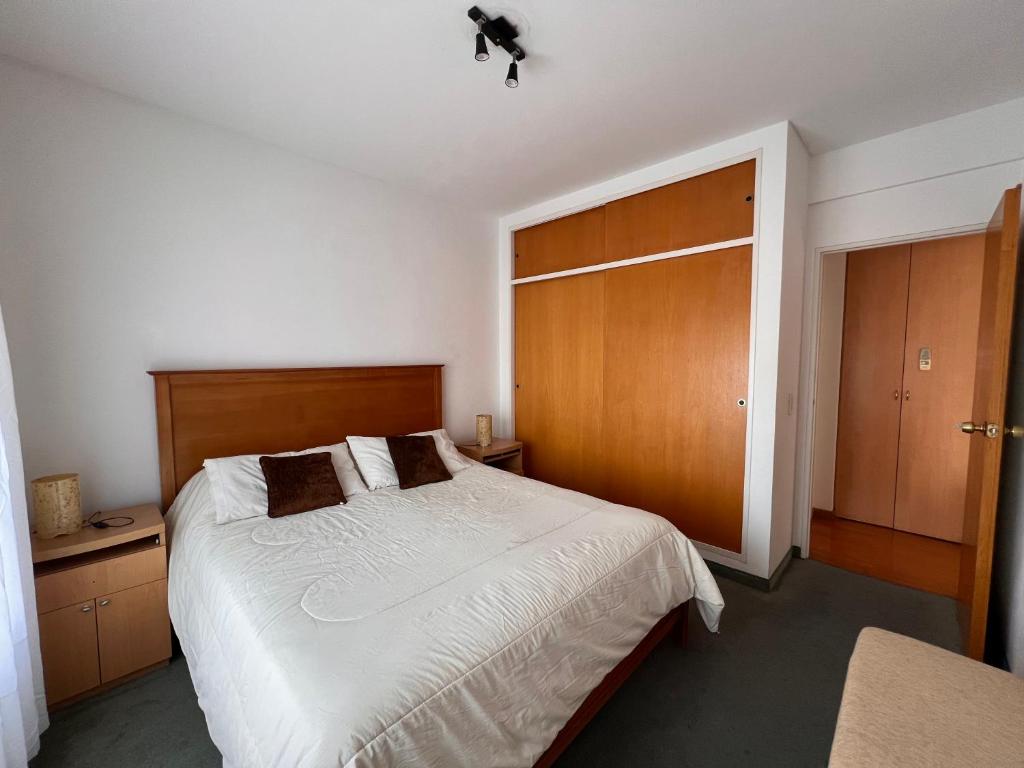 1 dormitorio con 1 cama grande y puerta de madera en Ocio Quesada en Buenos Aires