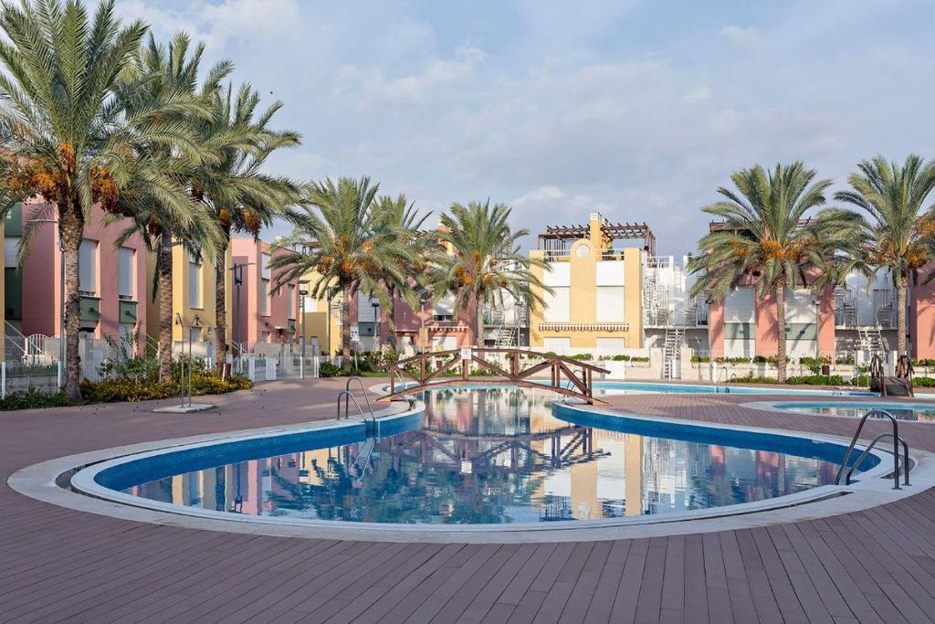 duży basen z palmami i budynkami w obiekcie Casa Antonia con jacuzzi privado y solarium w mieście Vera