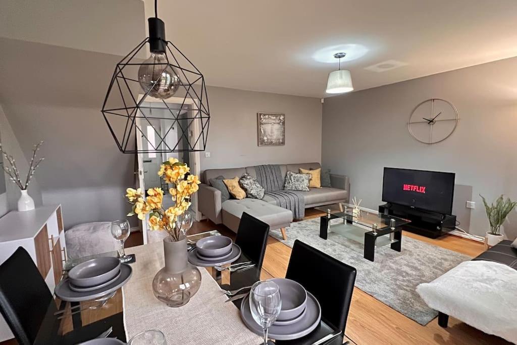 a living room with a couch and a table with chairs at Modern 3BR House For Contractors in Stockingford