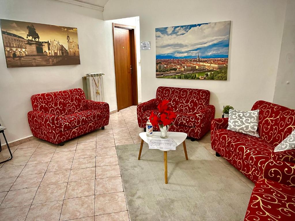 una sala de estar con 2 sofás rojos y una mesa. en B&B Da Lisa, en Turín