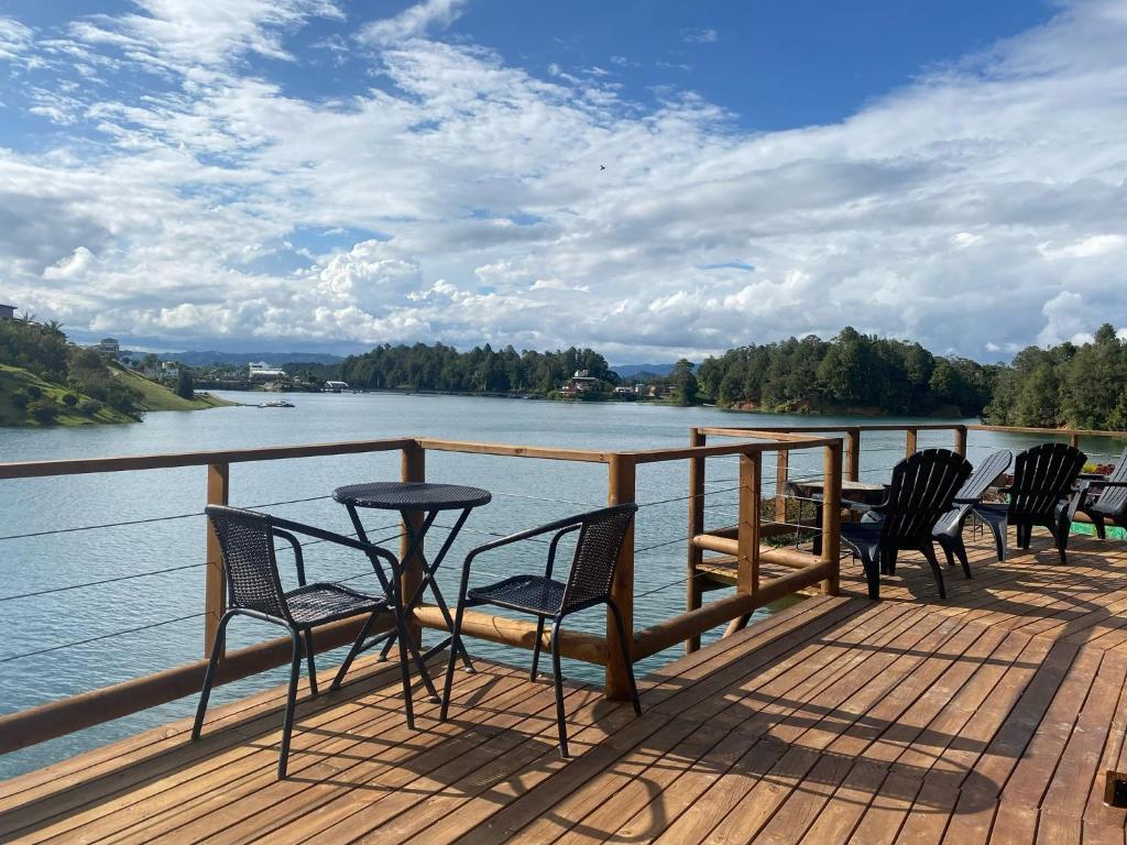 a group of chairs sitting on a deck overlooking a river at Ecolodge Bahia del Peñón in Guatapé