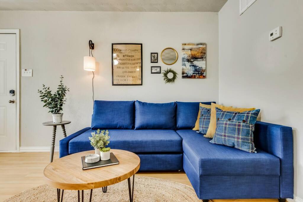 a blue couch in a living room with a table at The Classic • Near Knox Henderson in Dallas