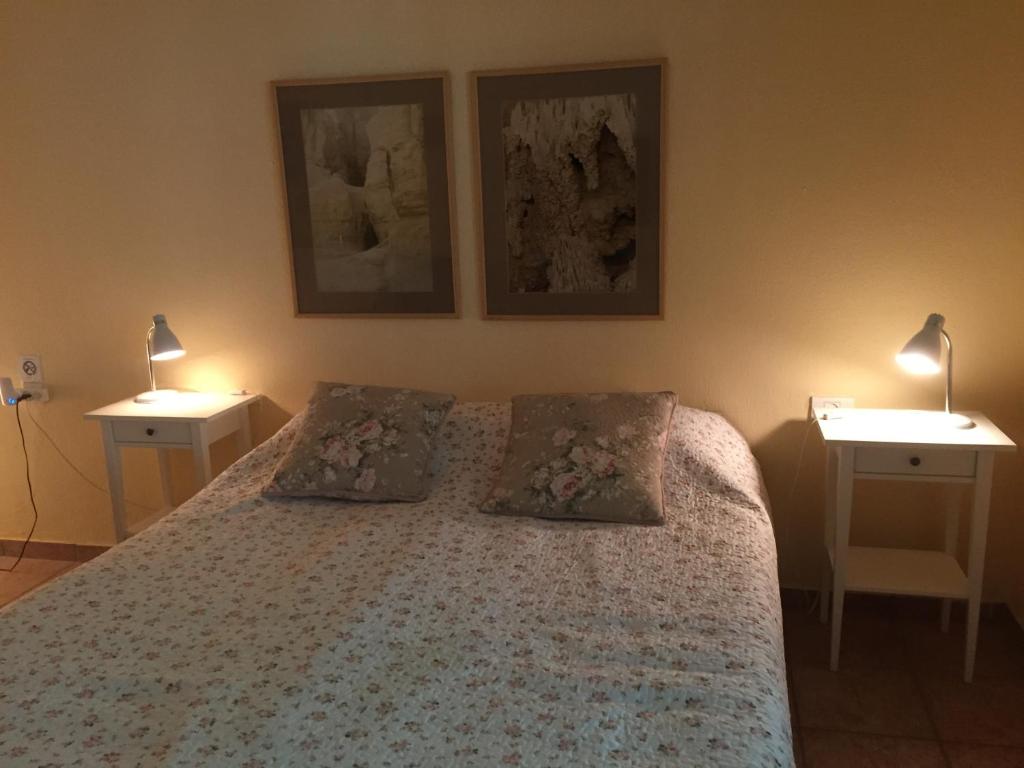 a bedroom with a bed with two nightstands and two lamps at Gil's Guest Rooms in Neve Zohar