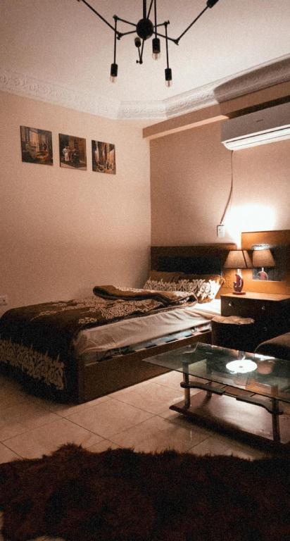 ein Schlafzimmer mit einem Bett und einem Tisch darin in der Unterkunft Comfy Apartment with private yard in 6 October city Cairo in Madinat as-Sadis min Uktubar