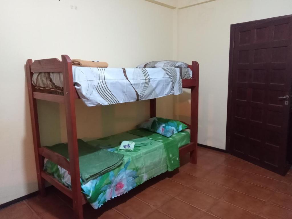 a bunk bed in a room with a door at Tucán Alojamiento in Puerto Iguazú
