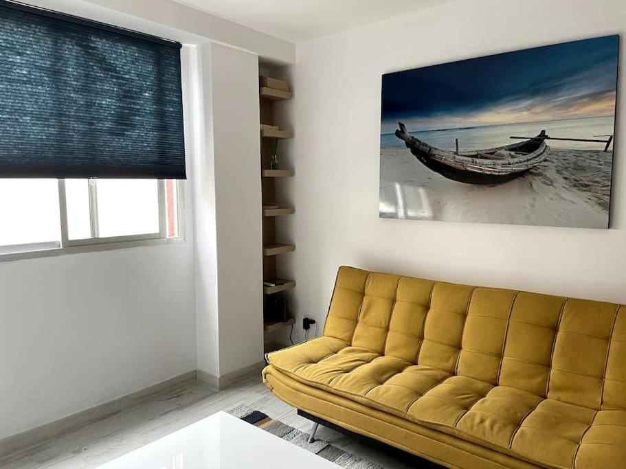 una sala de estar con sofá y una foto de un barco en Renovated modern apartment in the city center, en Santa Cruz de Tenerife