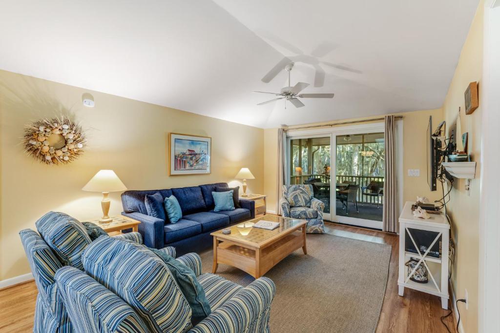 a living room with a blue couch and a table at Summerwind Cottage 1157 in Seabrook Island