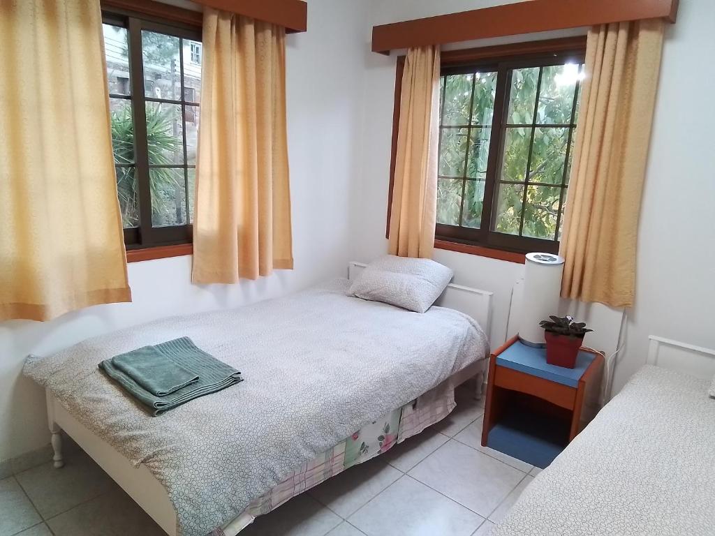 a bedroom with a bed and two windows at Kampi Double Storey House in the Village in Nicosia