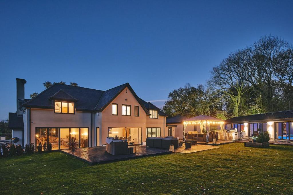 a large house with a backyard at night at Woodland House in Belbroughton