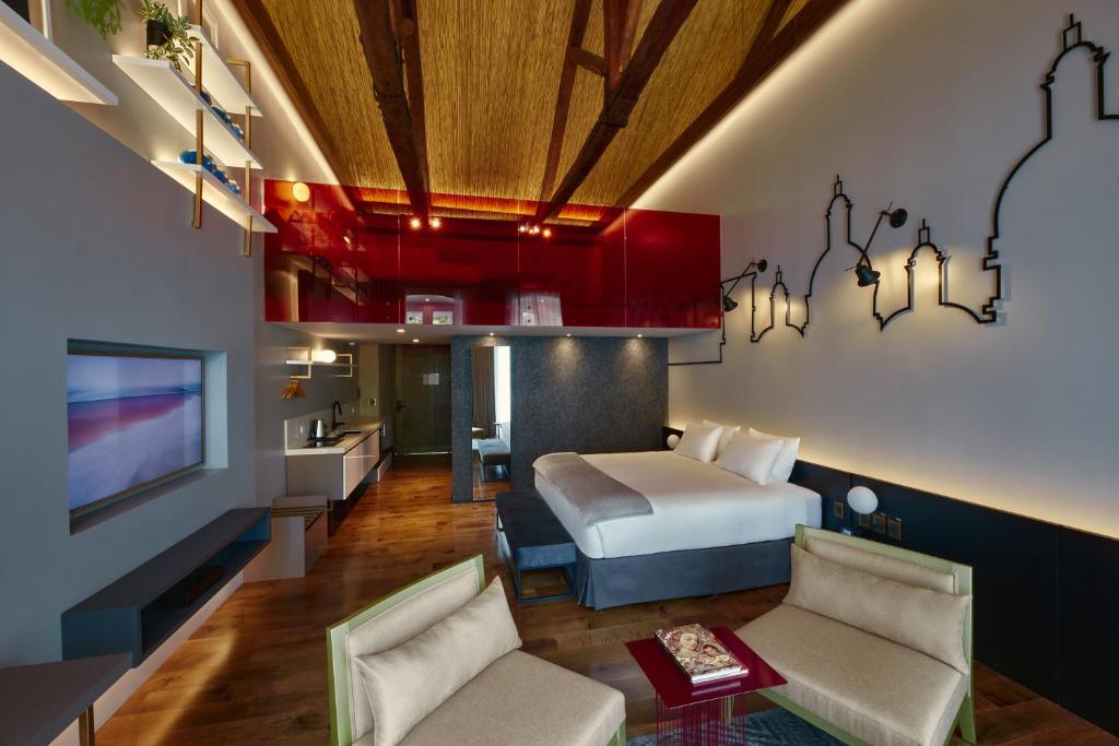Habitación de hotel con cama y TV en Casa Firenza Hotel & Suites Boutique, en Cuenca