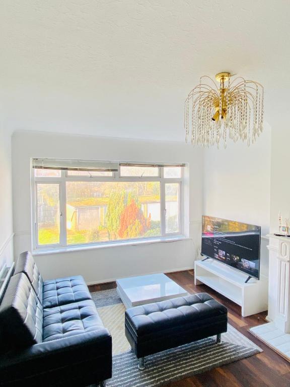 a living room with a couch and a chandelier at Cozy & Quiet Two Bedroom Apartment in Chingford