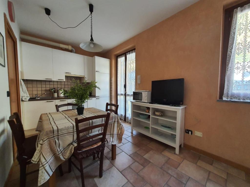 una cucina e una sala da pranzo con tavolo e TV di Residenza La Cascata a Calolziocorte