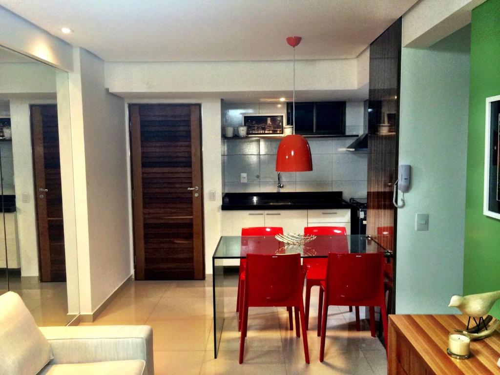 cocina y comedor con mesa y sillas rojas en Lindo apartamento no bairro de Manaira, en João Pessoa