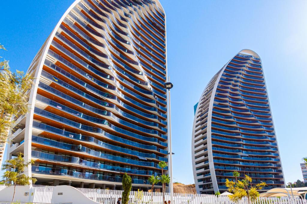 two tall buildings are next to each other at SUNSET WAVES superb apartments in Benidorm