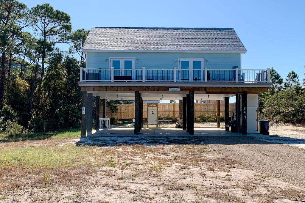 a blue house with a balcony on a porch at The Birdhouse in St. George Island