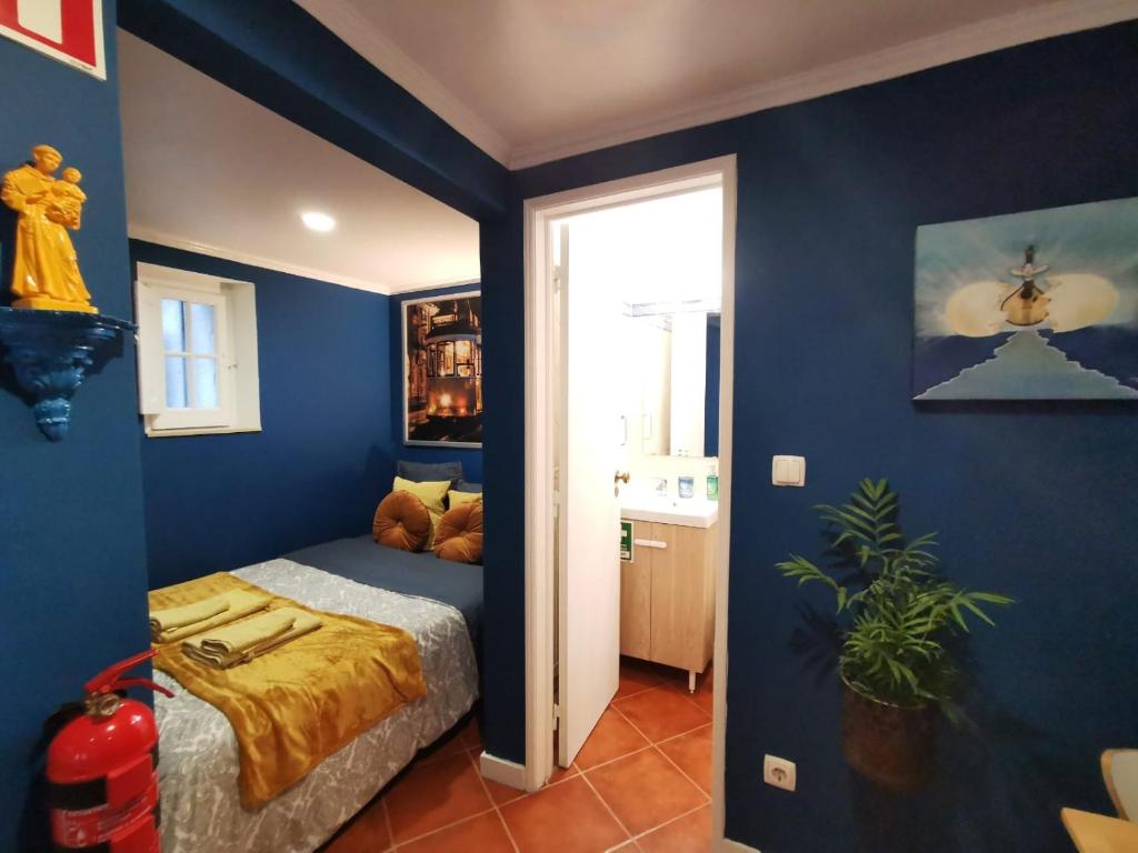 een slaapkamer met blauwe muren en een bed in een kamer bij Sto Antonio Guest House in Lissabon