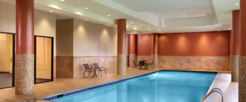 uma piscina num hotel com cadeiras e uma mesa em Sonesta Select Atlanta Cumberland Galleria em Atlanta