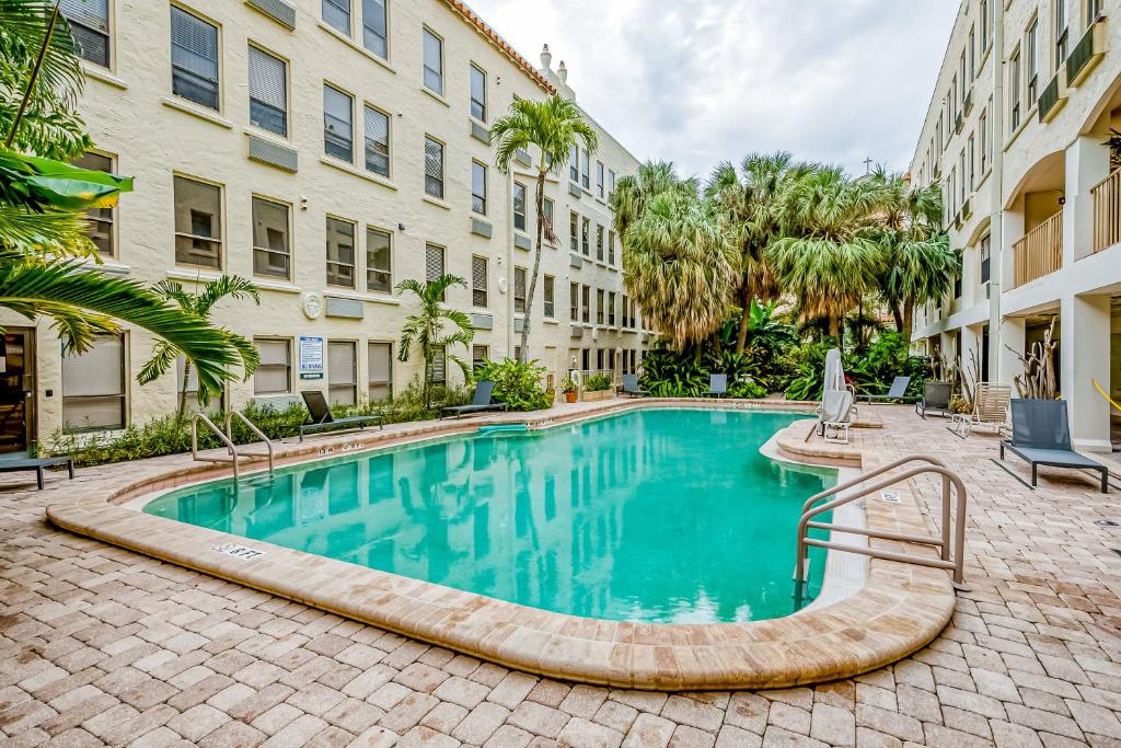 a swimming pool in front of a building at Palm Rising in Palm Beach