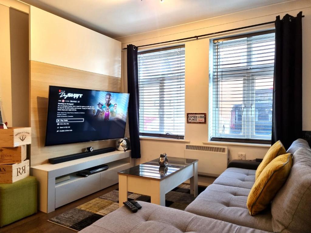sala de estar con sofá y TV de pantalla plana en The Belmont, Old Town, en Swindon