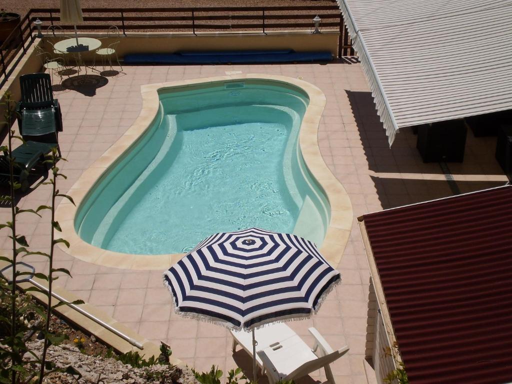 - un parasol à côté de la piscine dans l'établissement Gîte les Roziers, à Montmurat