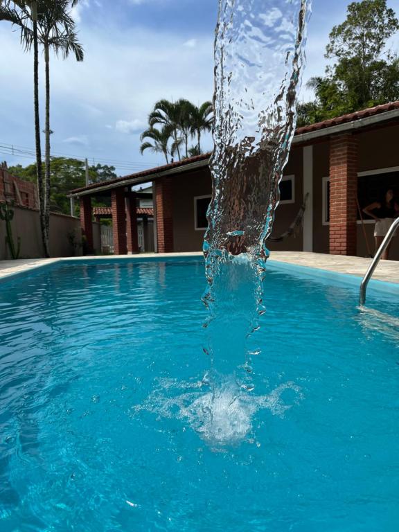 a water fountain in a swimming pool at Casa Paraíso - Cond Costa do Sol- Bertioga in Bertioga