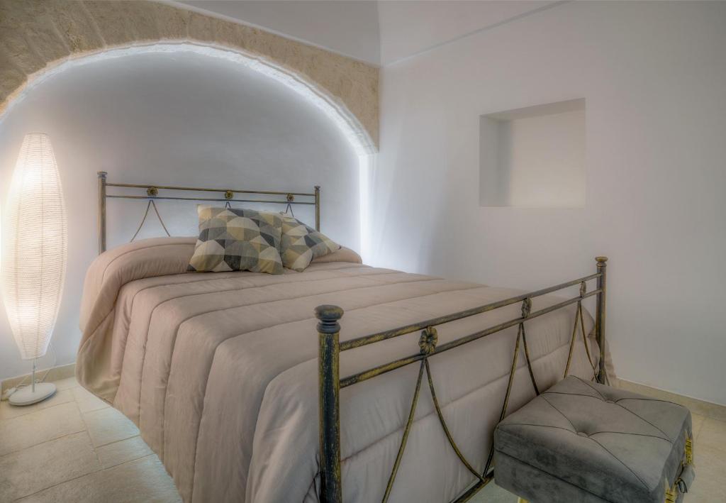 1 dormitorio con 1 cama en una habitación blanca en Home Pedra, en Ceglie Messapica