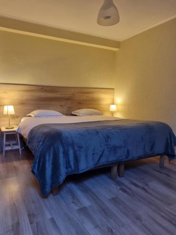 um quarto com uma cama grande e uma cabeceira em madeira em Isabel Guest House em Almada