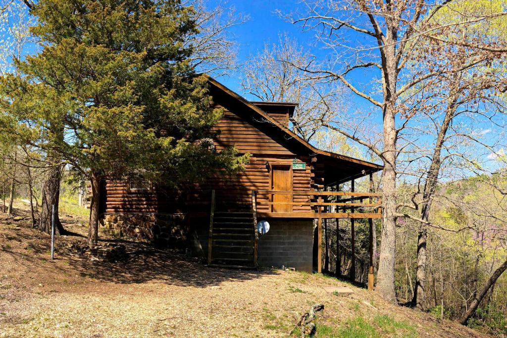 a log cabin in the middle of the woods at Charlie's Ol' Fishing Cabin in Eureka Springs