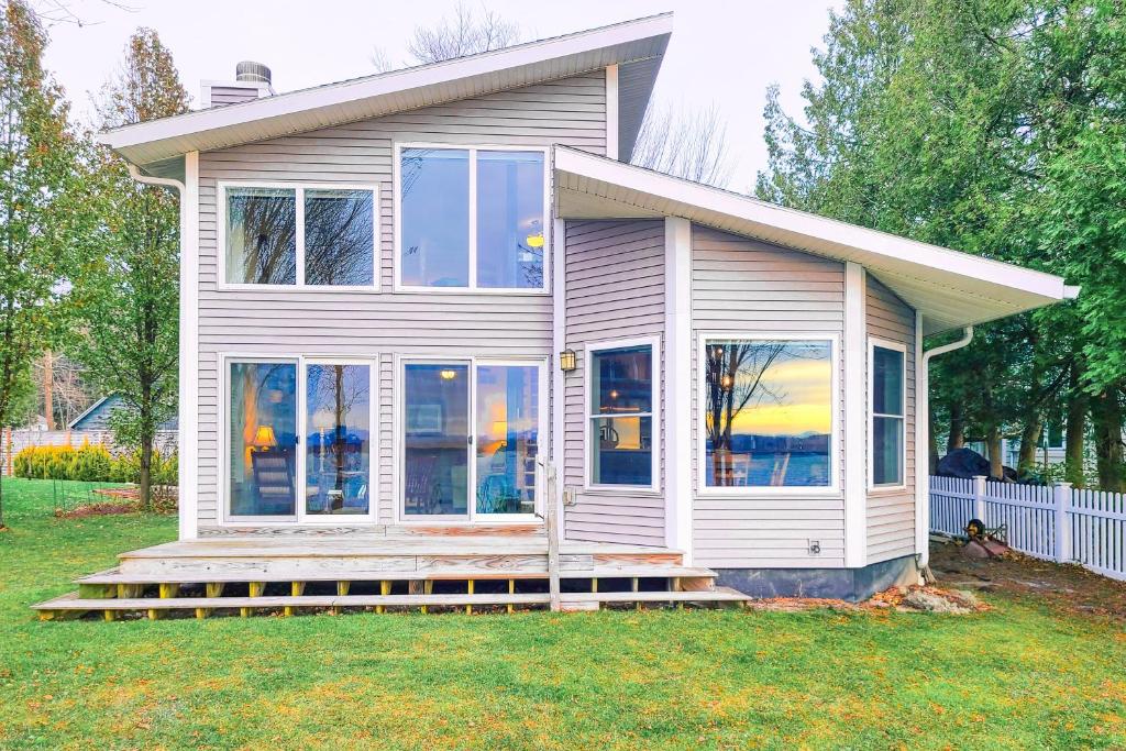 a small white house with large windows at Shelburne Bay Stay & Play in South Burlington