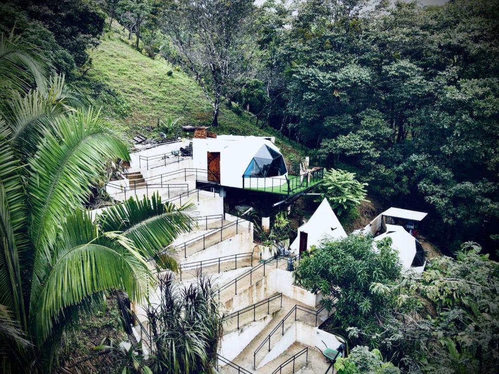 ein Haus an der Seite eines Hügels mit Treppen in der Unterkunft Glamping Tomaselli in Manuel Antonio