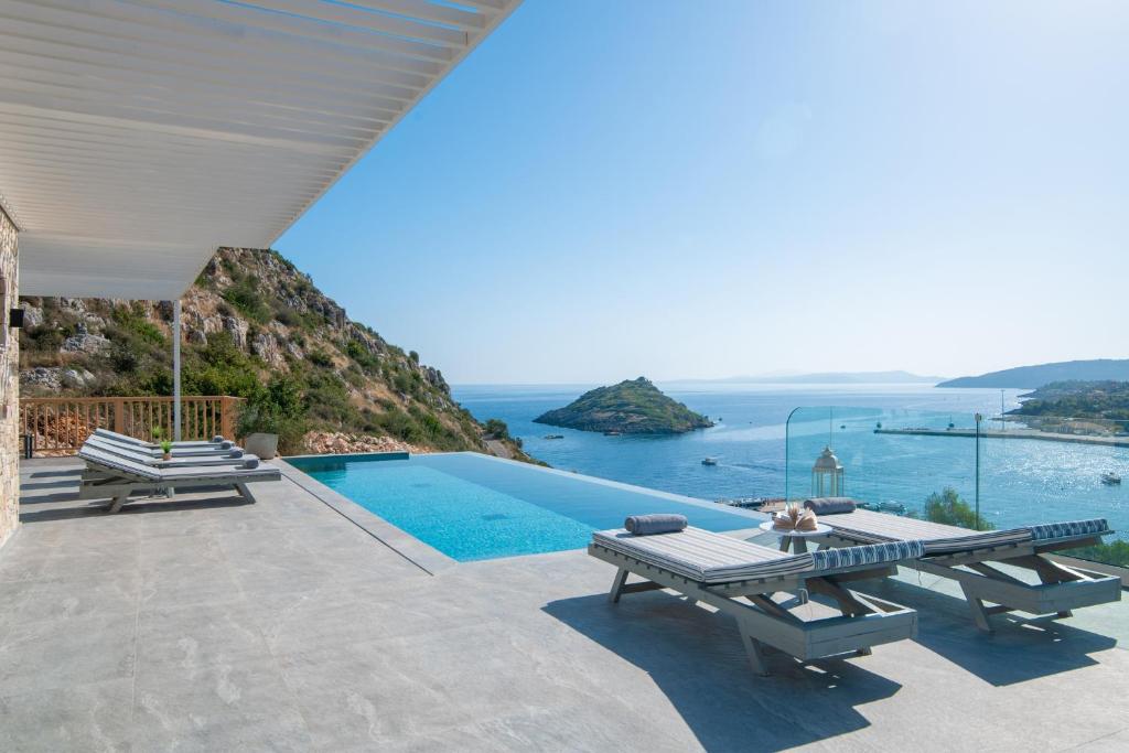 a villa with a pool and a view of the ocean at Villa Paganos in Volimes