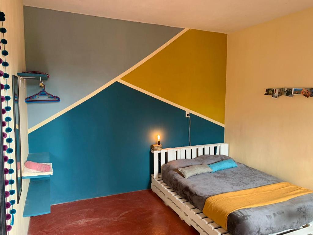 a bedroom with blue and yellow walls and a bed at Hostal 23 in San Cristóbal de Las Casas