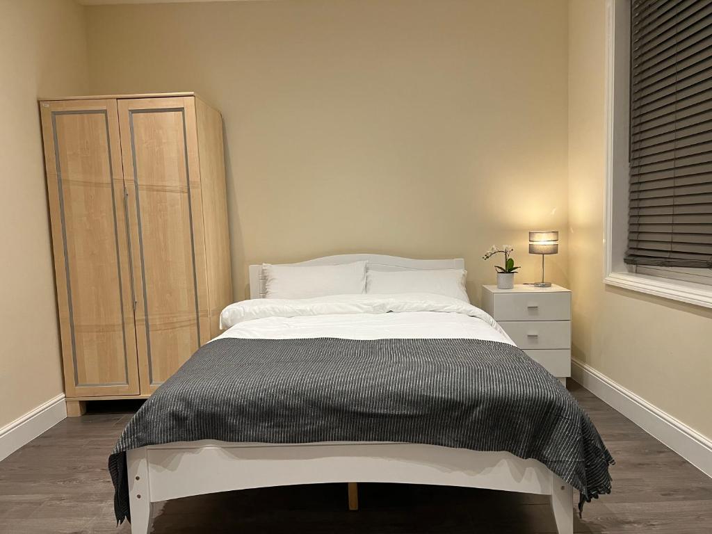 1 dormitorio con 1 cama grande y vestidor en BEAUTIFUL ROOMS ONLY FEW STEPS AWAY FROM BRUCE GROVE TOTTENHAM STADIUM, en Londres