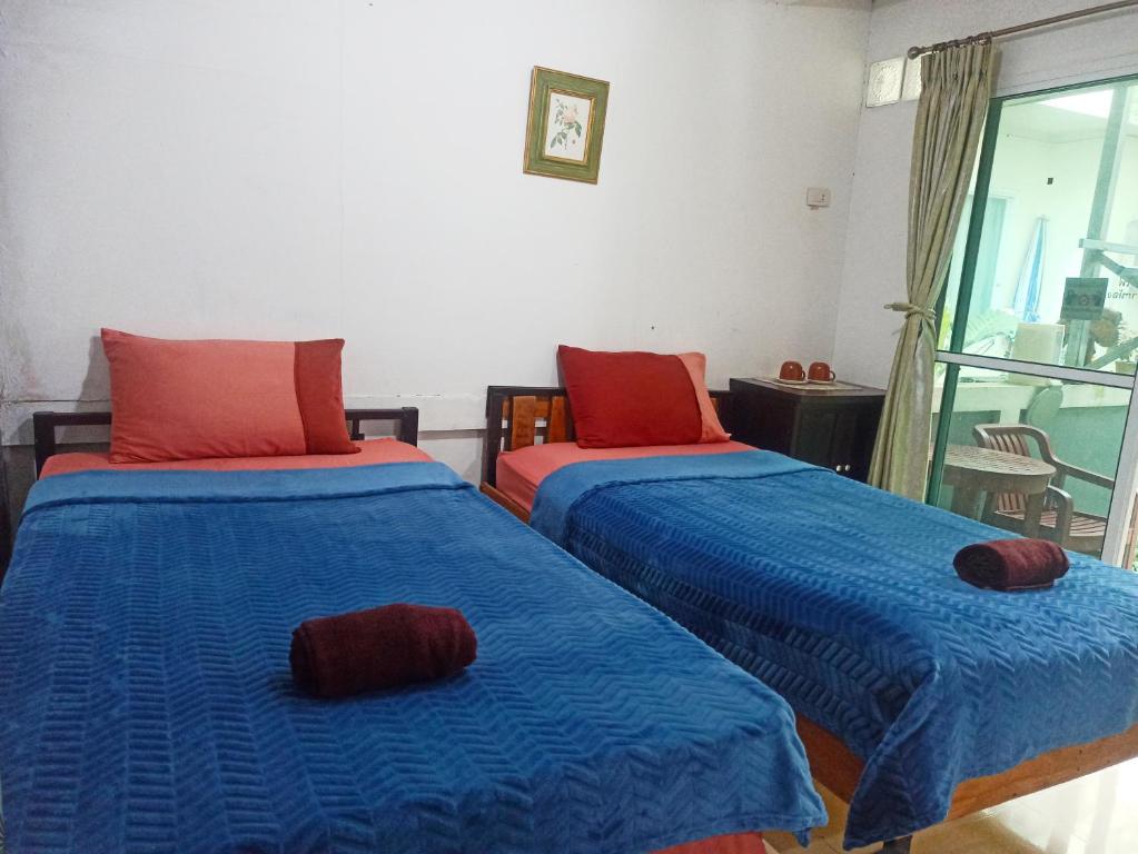 twee bedden in een kamer met blauw en rood bij Nu Phuket Airport Resident 1 in Nai Yang Beach