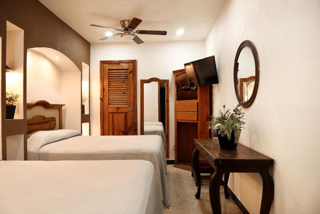 Habitación de hotel con 2 camas y espejo en Meson de Juan Valle, en Guanajuato