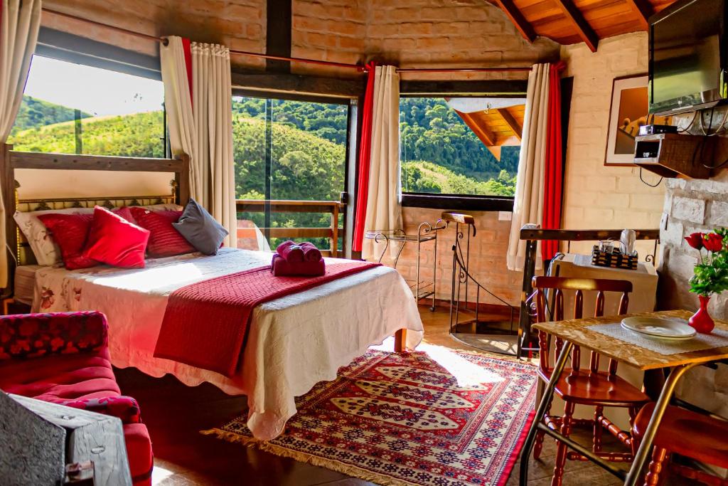 a bedroom with a bed and a large window at Pousada Chalé Sol Nascente in Santo Antônio do Pinhal