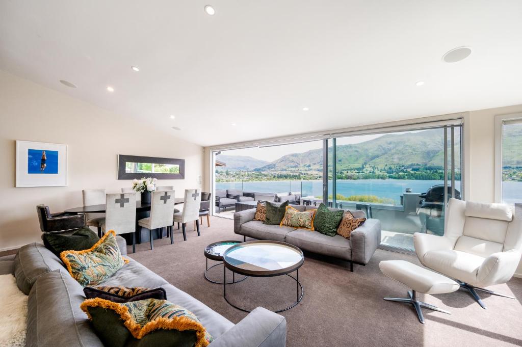 a living room with a couch and chairs and a table at Luxury Lakeview Vista Apartment in Wanaka