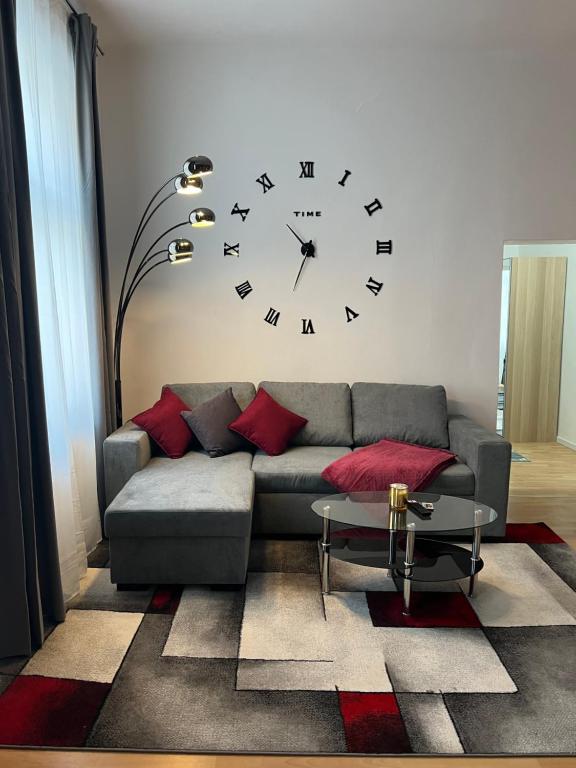a living room with a couch and a clock on the wall at Prater Tree big 3 room apartment near Innere Stadt in Vienna