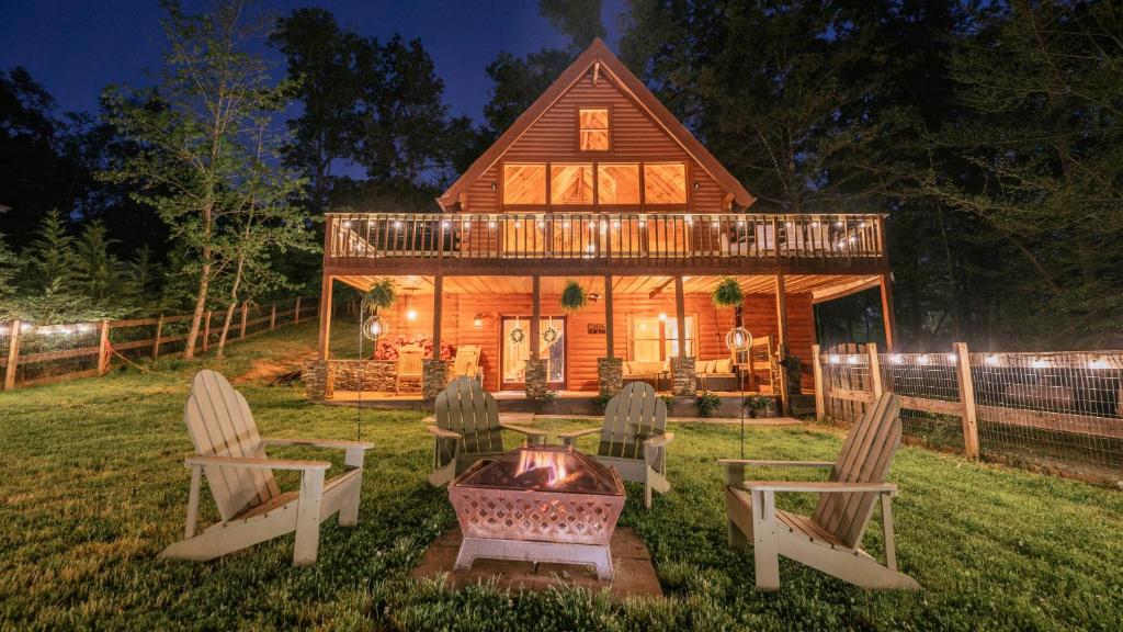 a cabin with chairs and a fire pit in the yard at Amenity Packed A-frame Cabin With Two Bedrooms And Loft in Gainesville