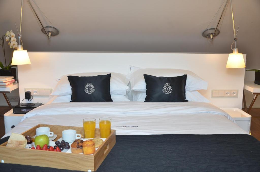 A neatly made double bed with a breakfast tray arranged at its foot.