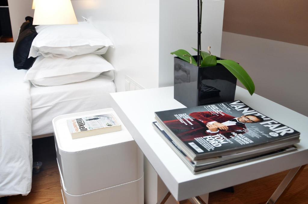 A small desk beside the bed, styled with books and an orchid.