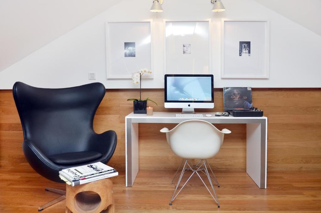 A compact desk setup with a computer and two different chairs.