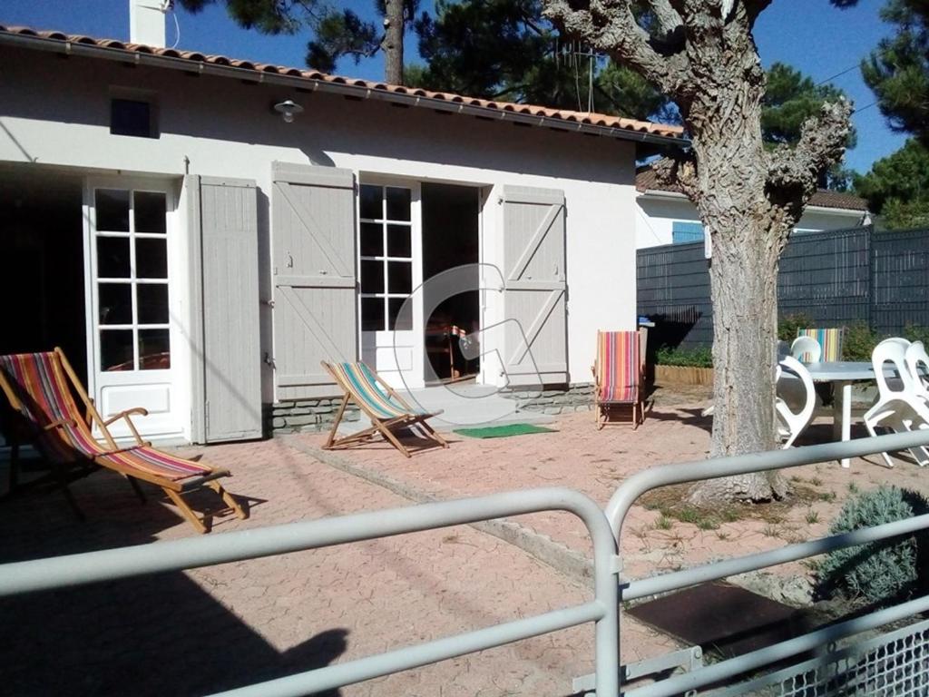 - un ensemble de chaises assises sur une terrasse en face d'une maison dans l'établissement Maison 6 pers à 200m de la plage du Rocher, La Tranche-sur-Mer – Confort et activités familiales - FR-1-357-234, à La Tranche-sur-Mer