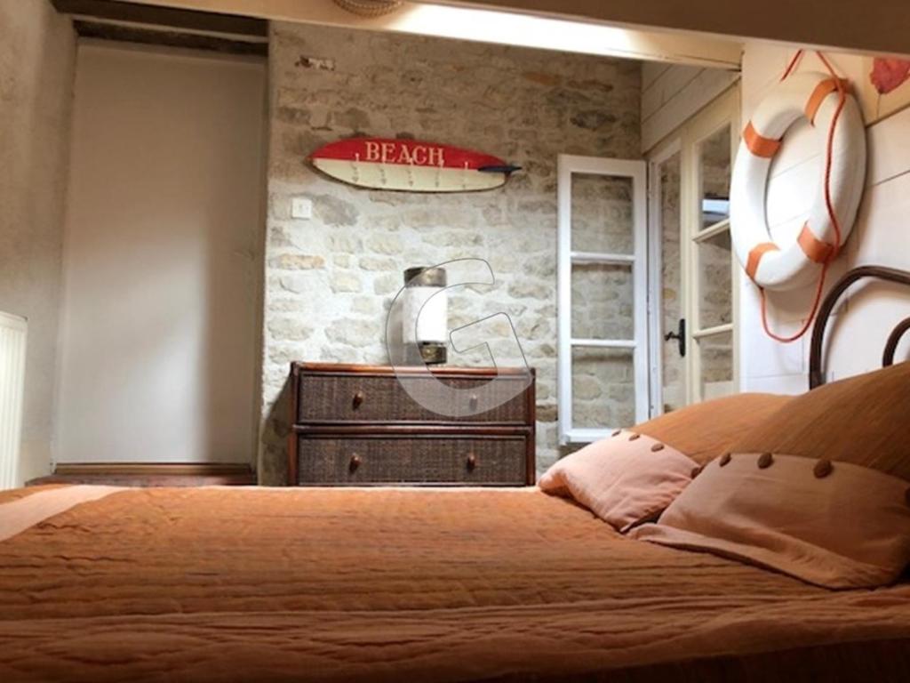 a bedroom with a bed and a surfboard on the wall at Maison Le Bernard, 5 pièces, 6 personnes - FR-1-357-253 in Le Bernard