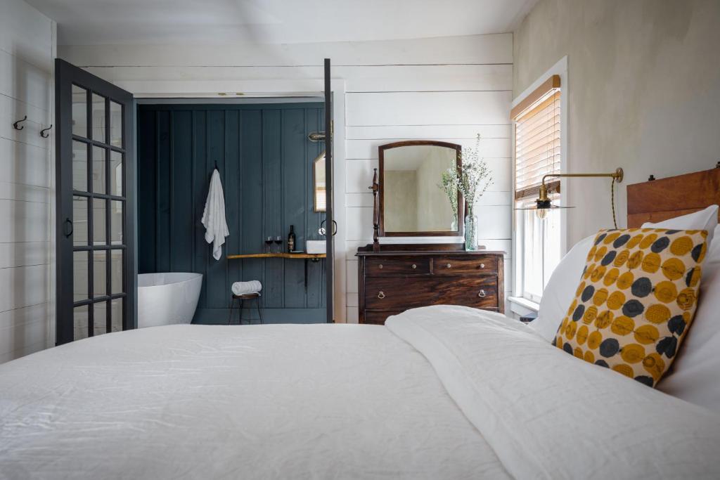 een slaapkamer met een bed en een badkamer met een bad bij Howland House in Mount Tremper