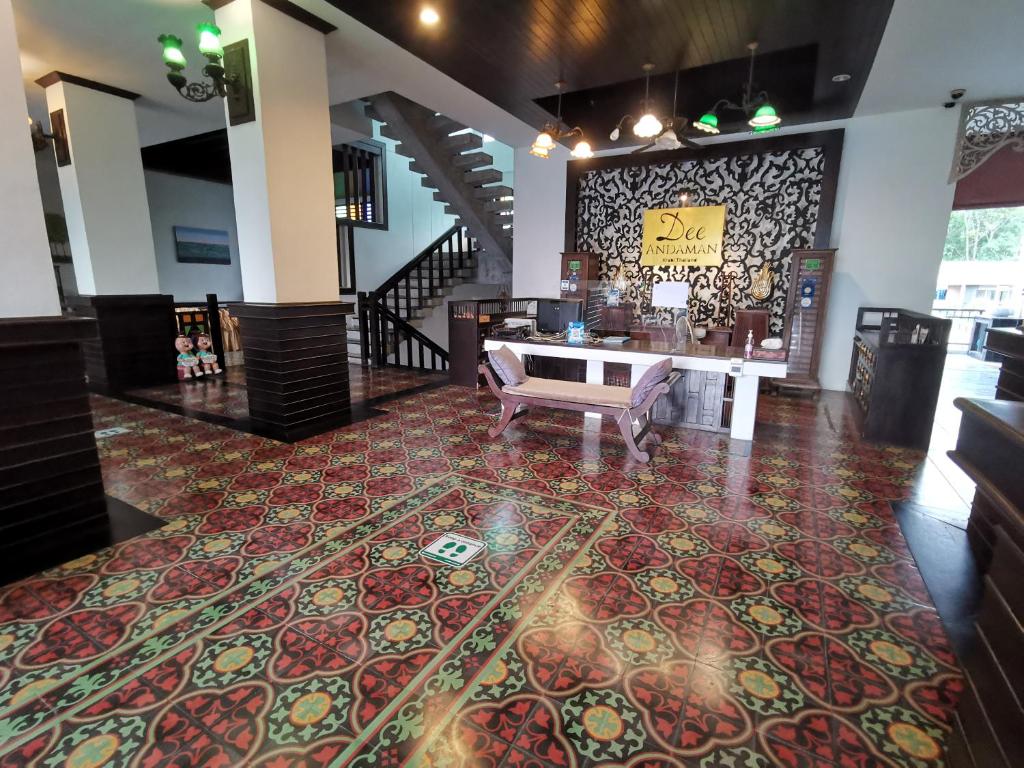 a lobby with a table and a rug on the floor at Dee Andaman Hotel in Krabi