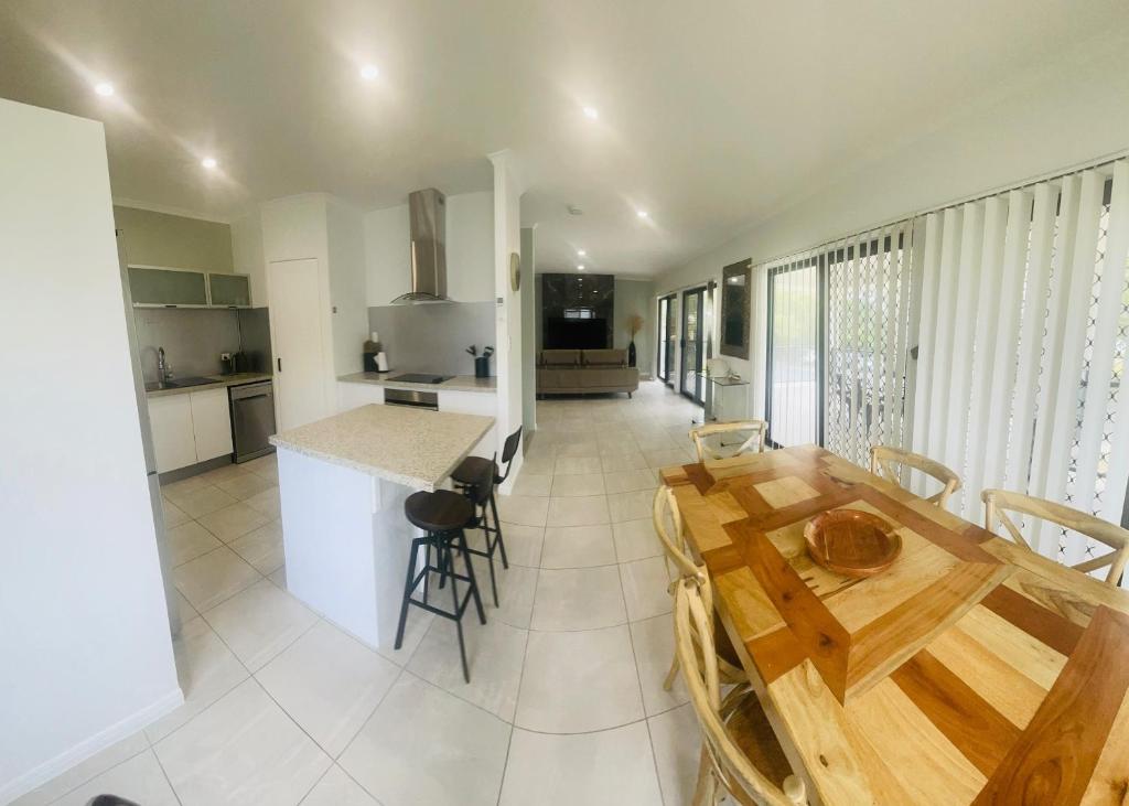 a kitchen and dining room with a wooden table at 3 Seacrets at Shelly in Urangan