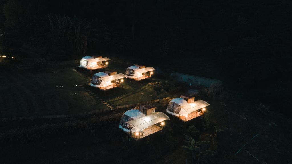 an overhead view of a group of tents in the water at night at Dome บ้านสกายพฤกษ์ in Mon Jam