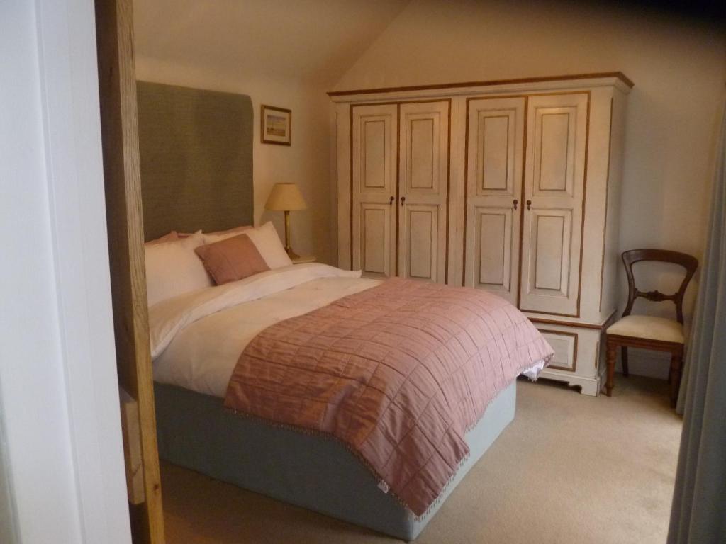 - une chambre avec un lit, une armoire et une chaise dans l'établissement Hunger Barn, à Norwell